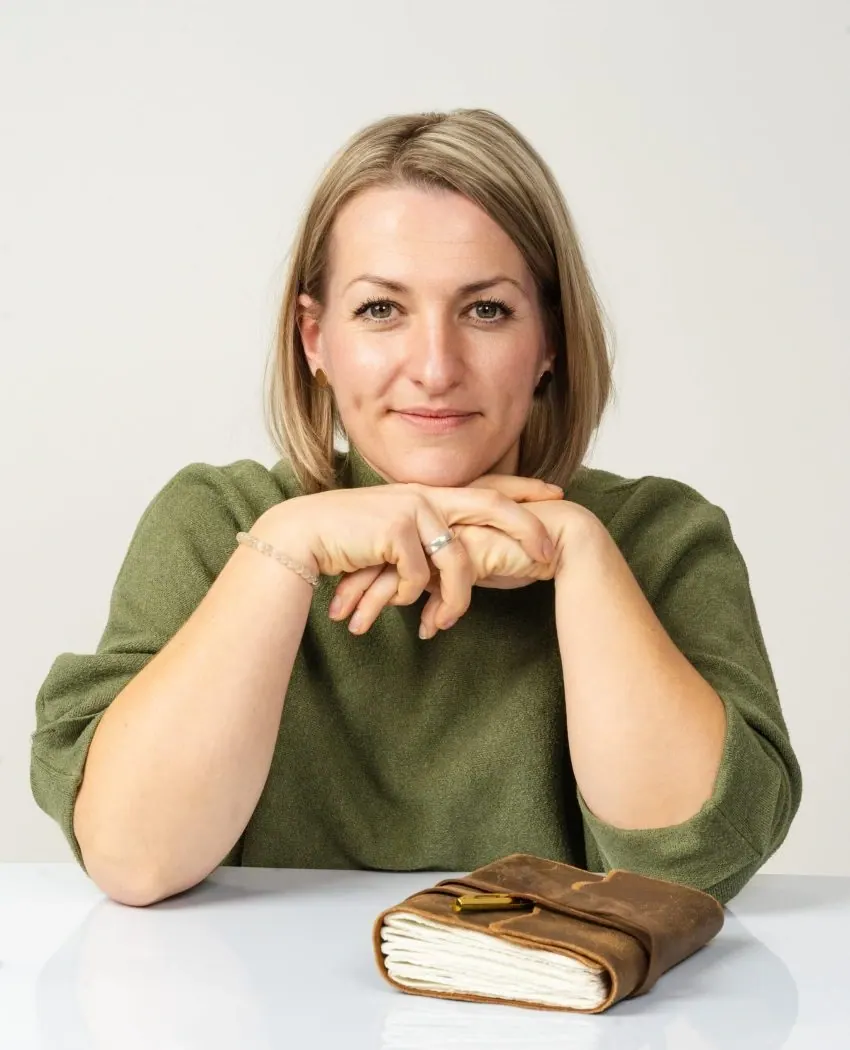 Renée Zweck, systemische Beraterin, stützt lächelnd ihr Kinn auf die Hände